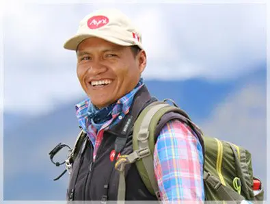 A man with a backpack and hat smiling for the camera.