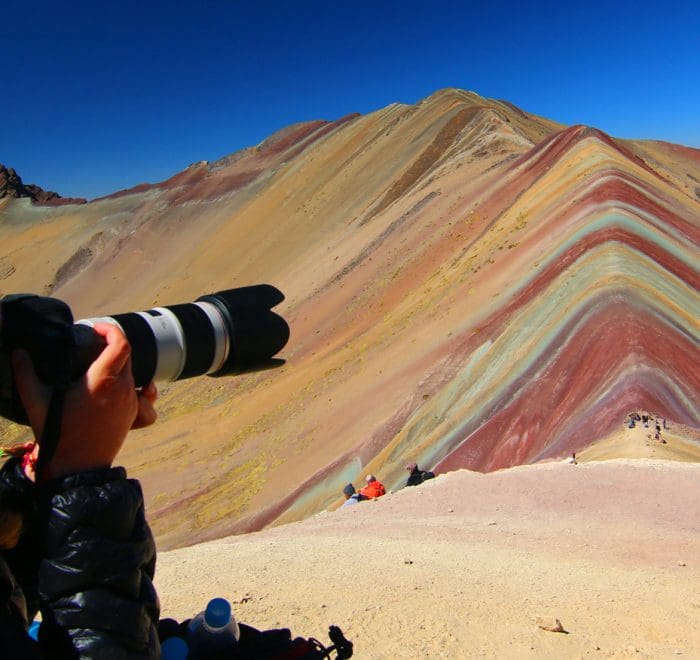 A person taking pictures of the rainbow mountains